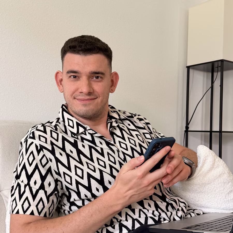 Eddie A. smiling, phone in hand, laptop on his lap